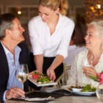 Waitress Serving Food To Senior Couple In Restaurant during a bridge tournament