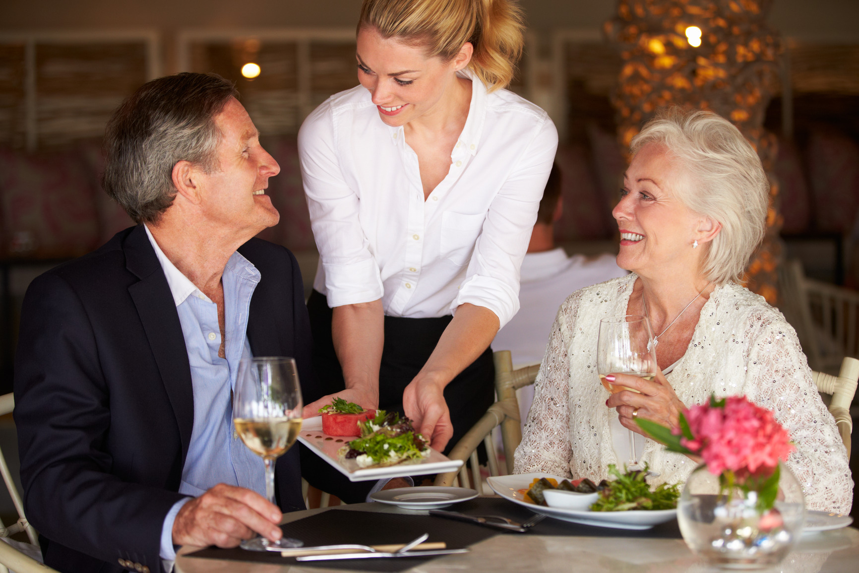 Waitress Serving Food To Senior Couple In Restaurant during a bridge tournament