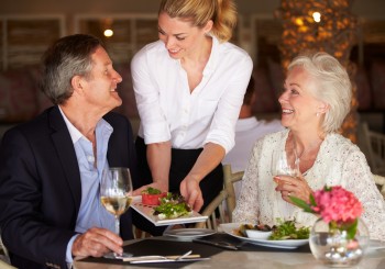 Waitress Serving Food To Senior Couple In Restaurant during a bridge tournament