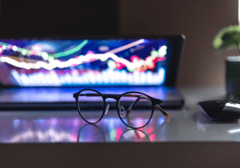Photo of a laptop with electronic light pattern on the screen and eyeglasses in the foreground to illustrate an article titled 5-Affordable Casino Platforms for Entrepreneurs