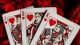 Photo of the Jack, Queen and King of hearts playing cards placed on a red plush background for article titled How Aggregators Expand Table-Game Choices for Card Fans