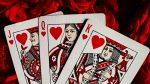 Photo of the Jack, Queen and King of hearts playing cards placed on a red plush background for article titled How Aggregators Expand Table-Game Choices for Card Fans