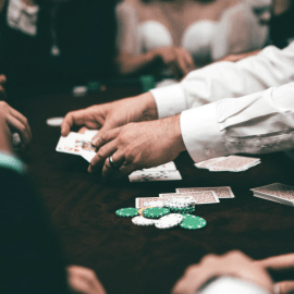 dealer and players playing a card game at a casino