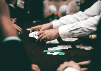 dealer and players playing a card game at a casino